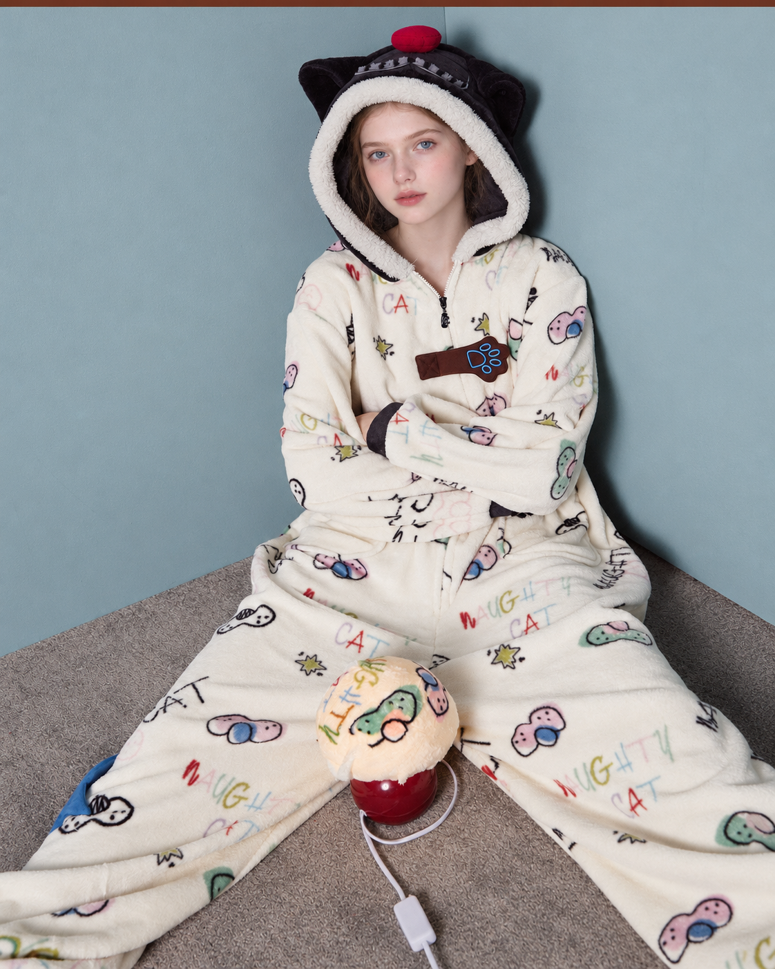 Doodlewhisk Cat-Doodle Hooded One-Piece Pajamas – floor-seated view of the cream one-piece - Roomden