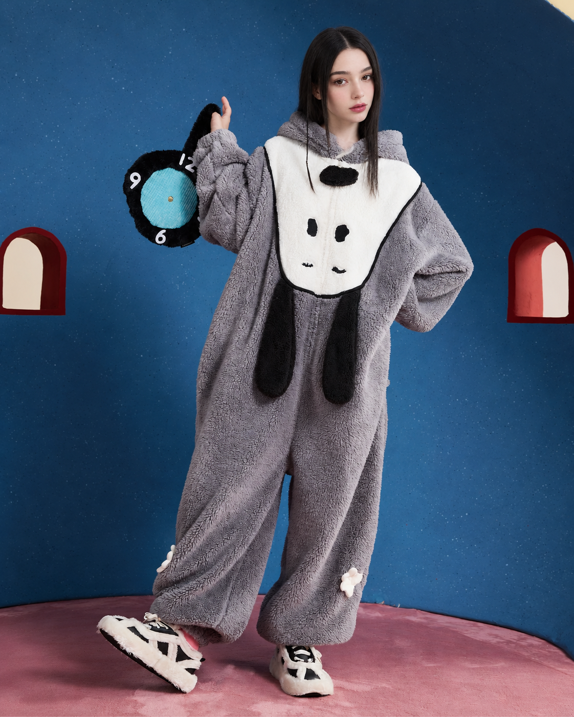 Dog-Face Hooded Fleece One-Piece Pajamas – gray standing view holding a soft clock with one foot extended - Roomden