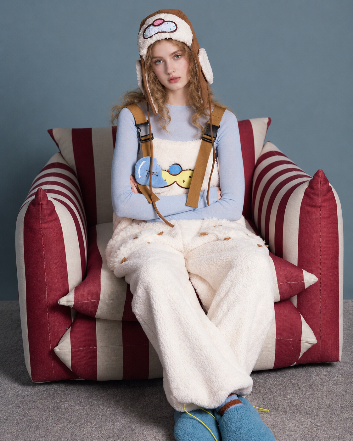 Cat-paw plush one-piece pajamas – cream front seated view on striped armchair - Roomden