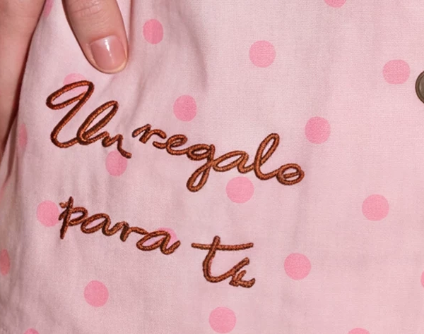 Close-up of letter decoration on pink polka dot pajama fabric