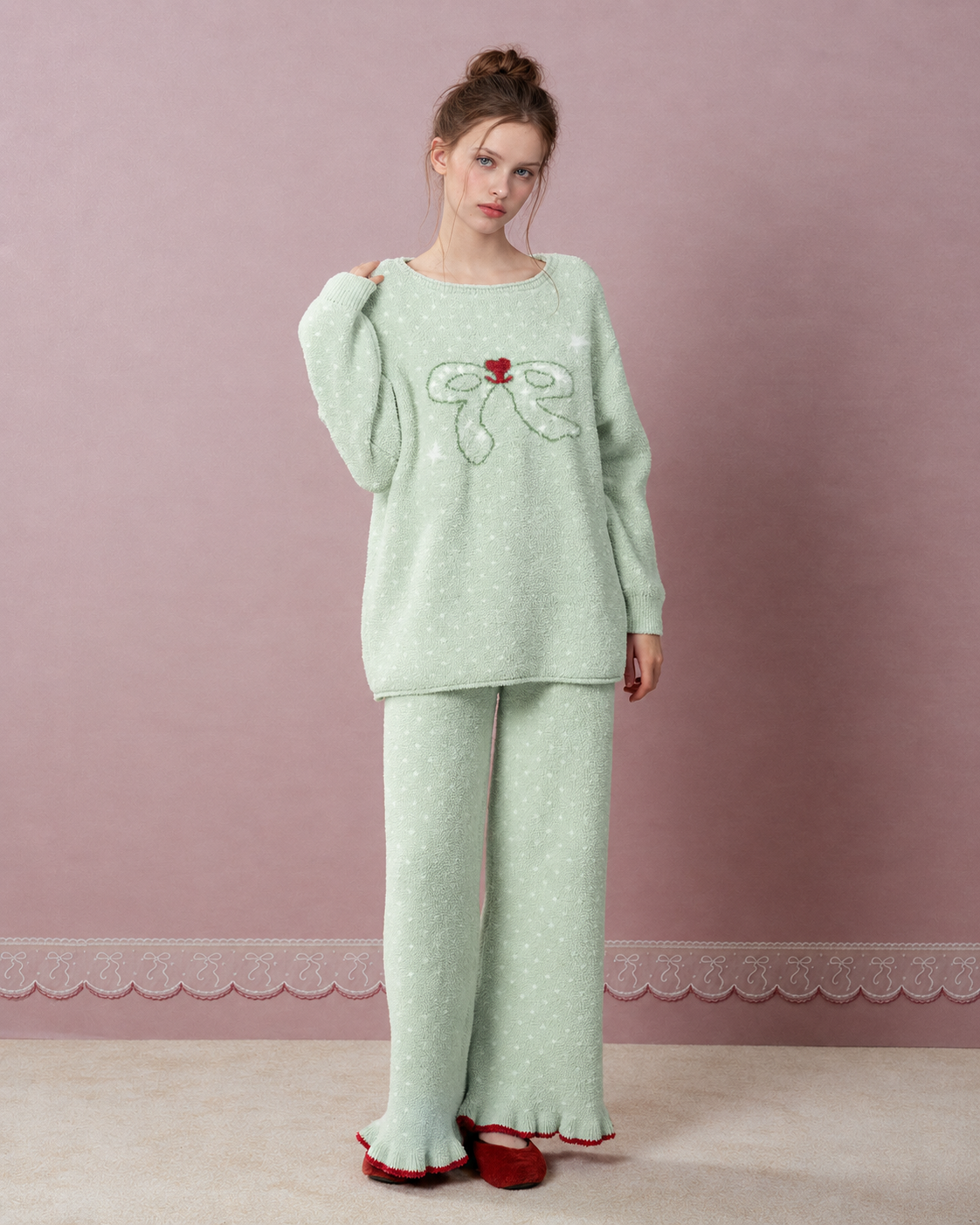 Bow and Heart Fleece Pajama Set – Apple green standing with one hand at the neckline - Roomden