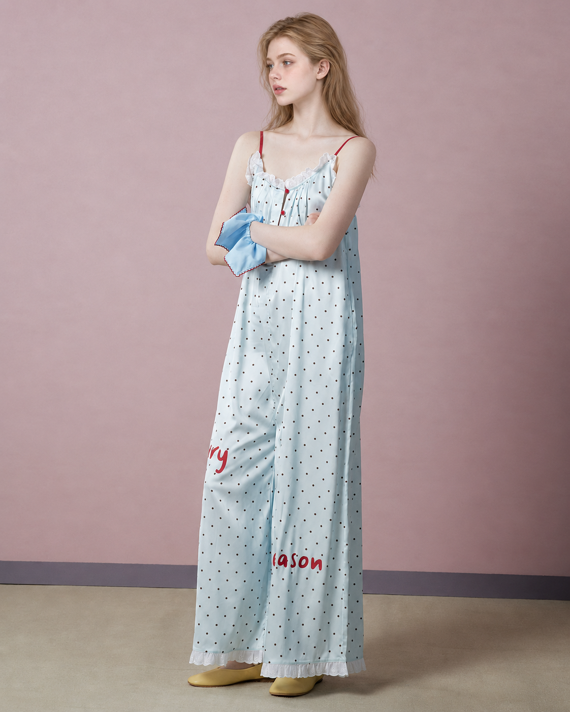 Full-length side-front view of pale blue polka dot pajama jumpsuit - Roomden