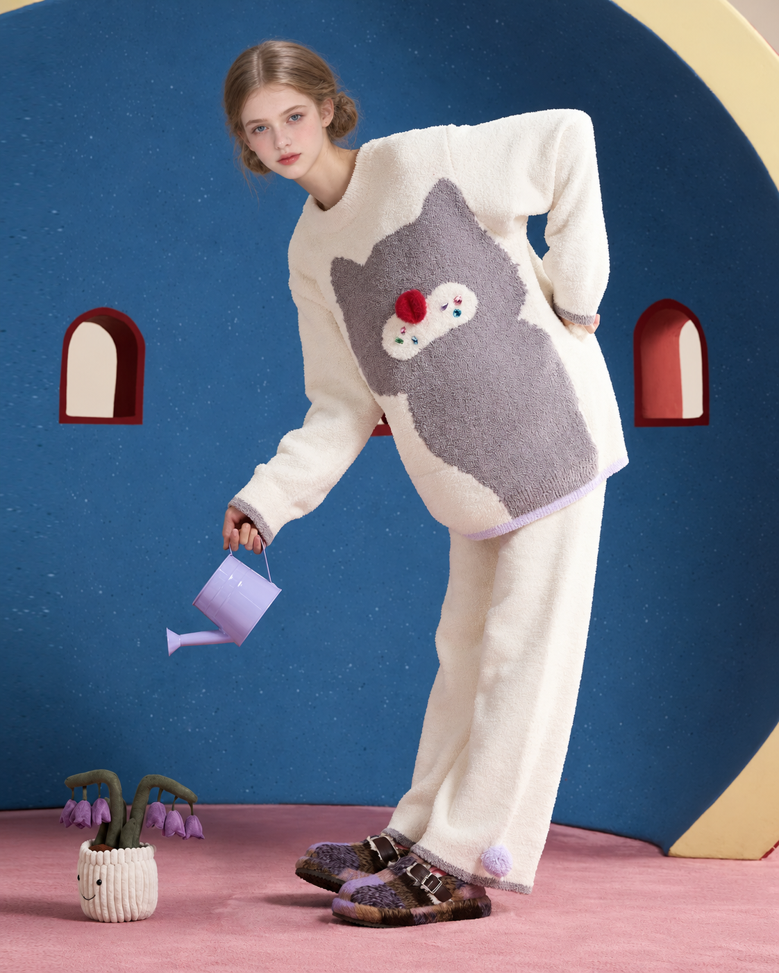 Ivory cat graphic pajama set – leaning pose with a lavender watering can against a blue wall - Roomden