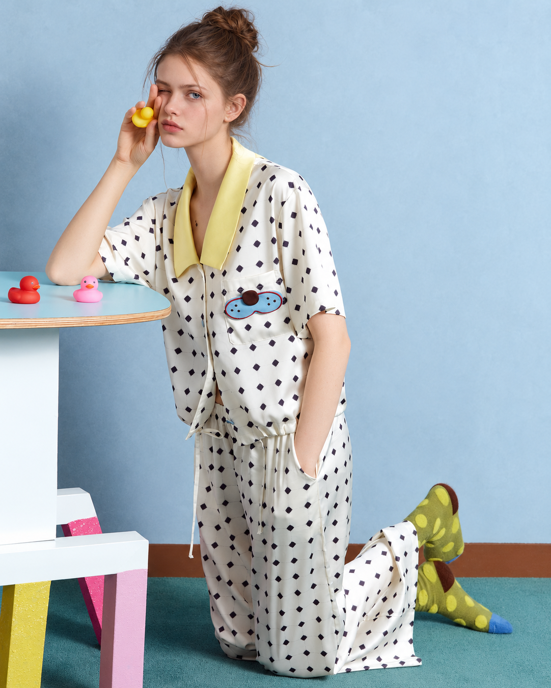 Lemonpause Short-Sleeve Pajama Set – ivory kneeling pose with a yellow duck prop - Roomden