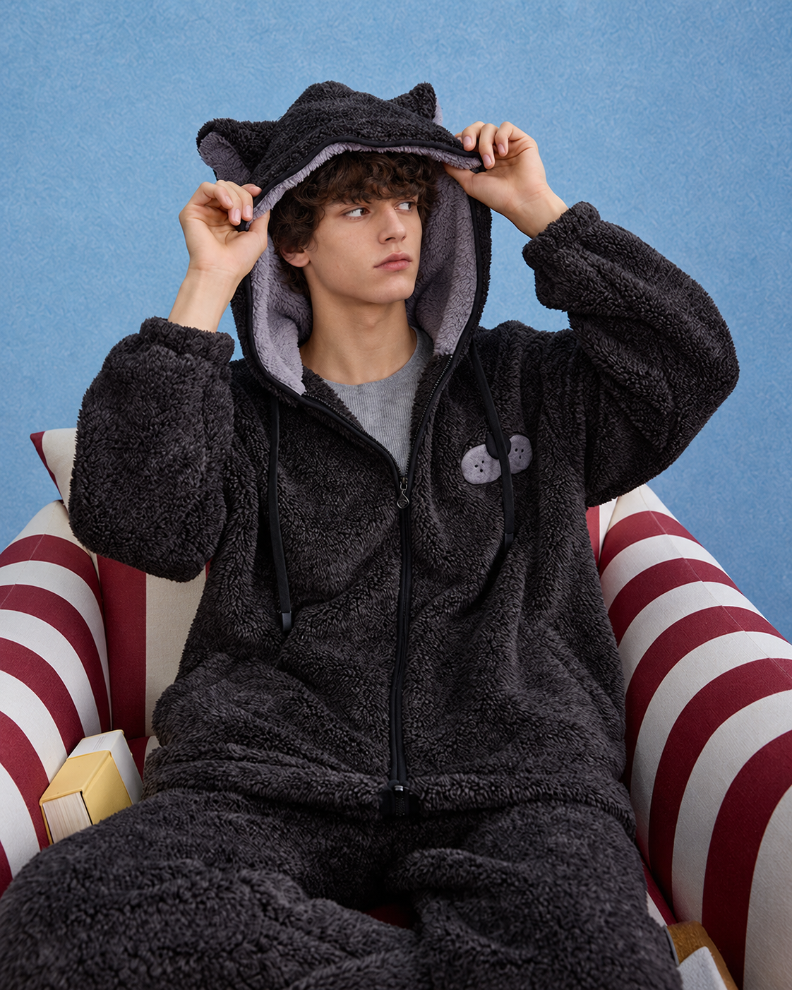Men's Cat-Ear Hooded Fleece Pajama Set – dark gray seated in a striped armchair - Roomden