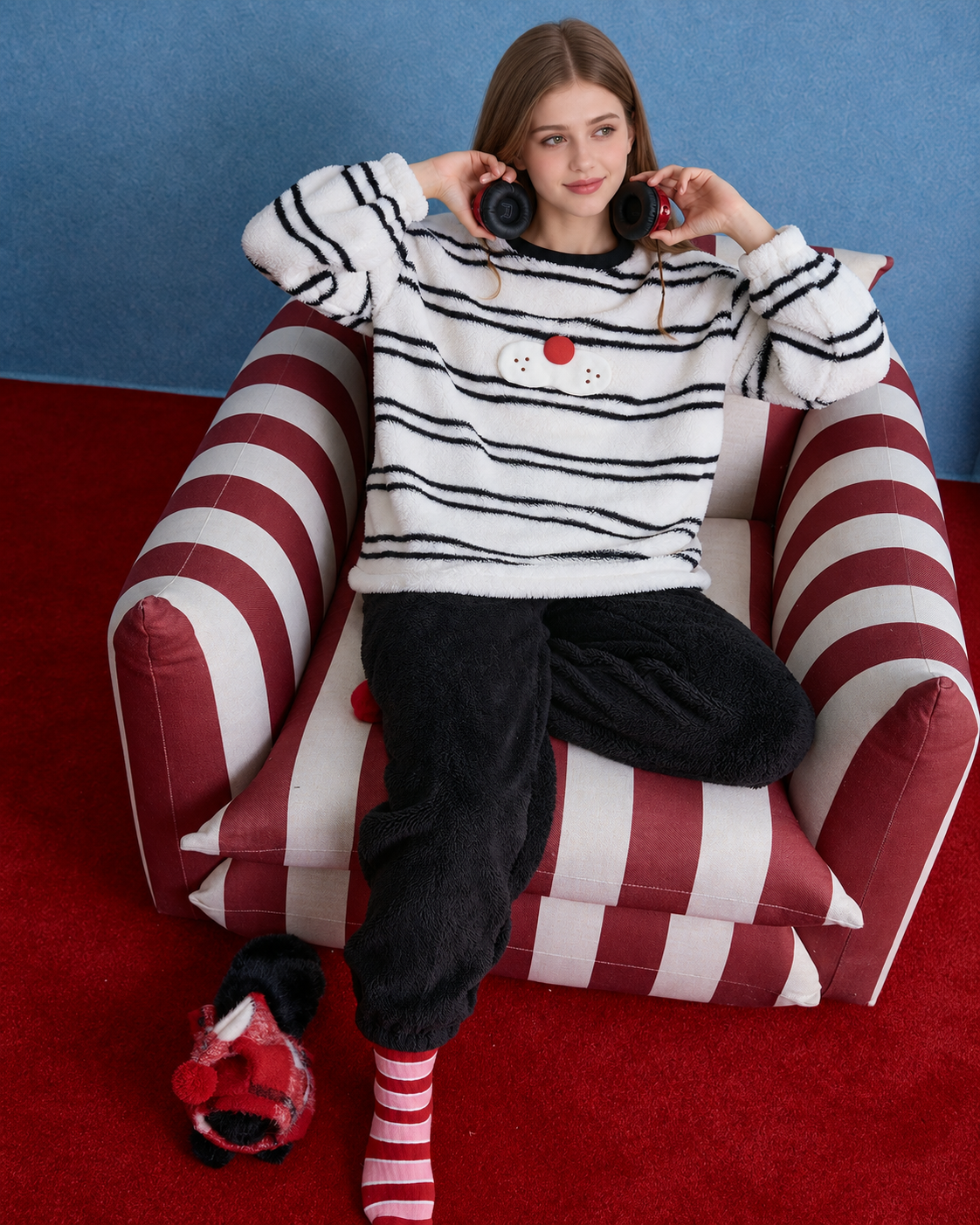 Whiskerbeat striped cat plush pajama set - Seated full view holding headphones at the neck - Roomden