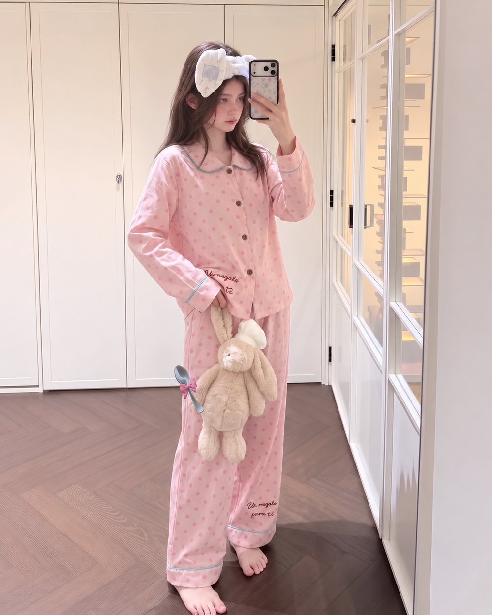 Front standing view of pink polka dot cotton pajama set with turquoise piping