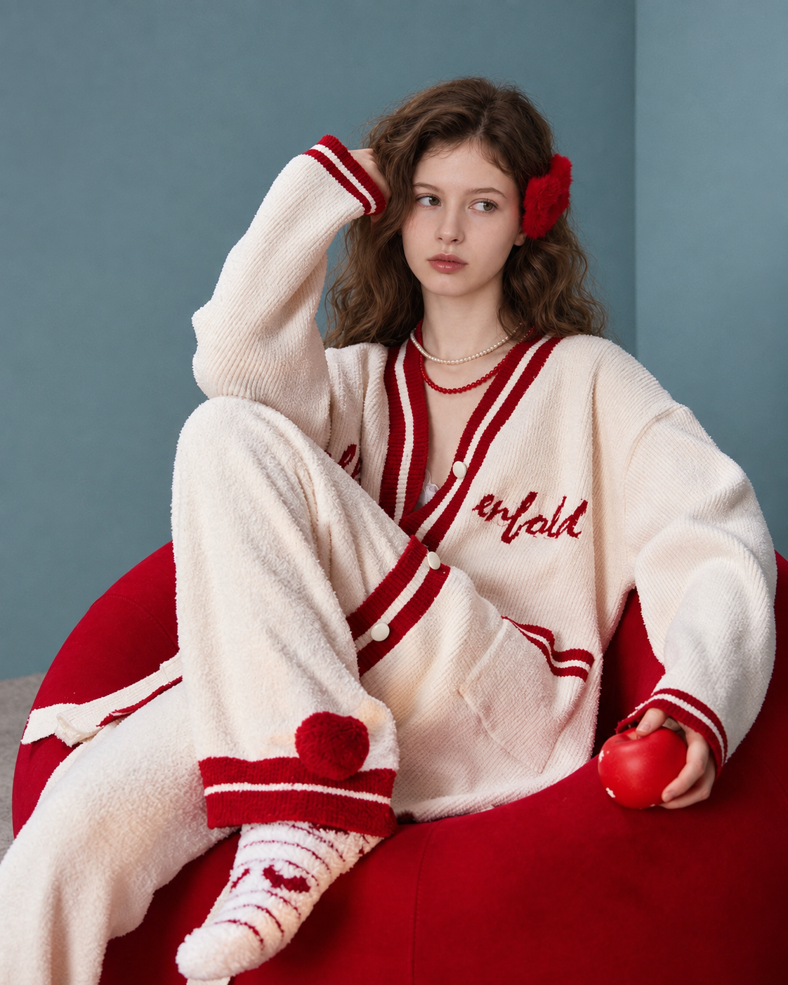 Seated view showing cardigan and pom-pom trouser cuffs