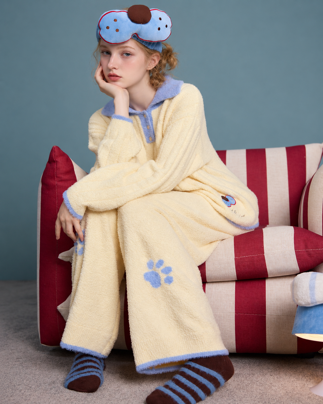 Plush Paw Print Pajama Set – cream yellow and blue seated view on a striped sofa - Roomden