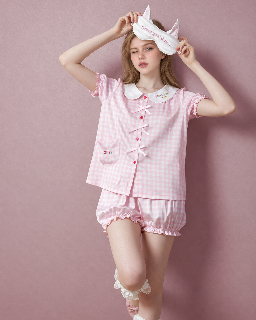 Front view of pink gingham bow pajama top and gathered shorts.