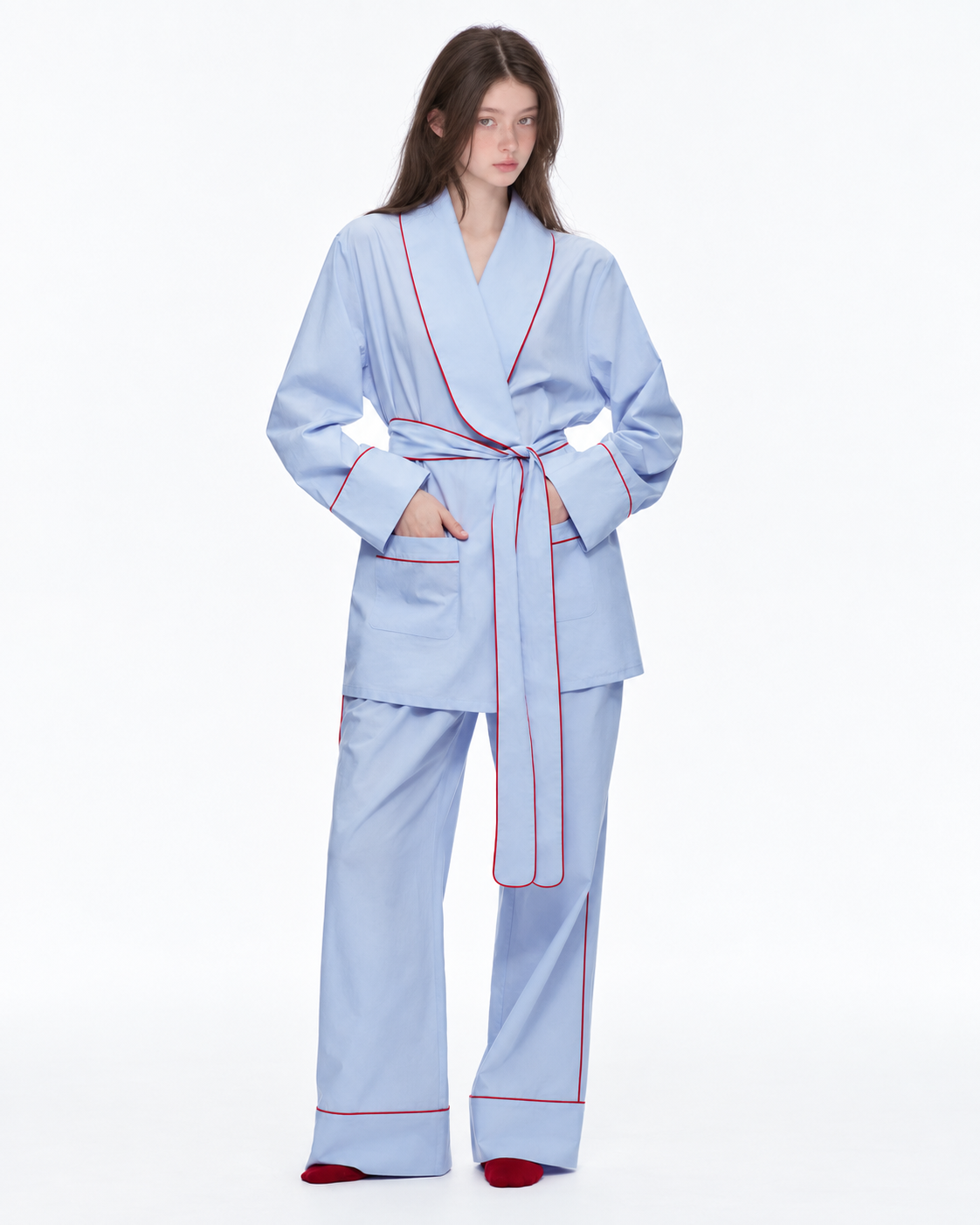 Linehaven wrap pajama set – Baby Blue, front view with hands in pockets in the studio - Roomden