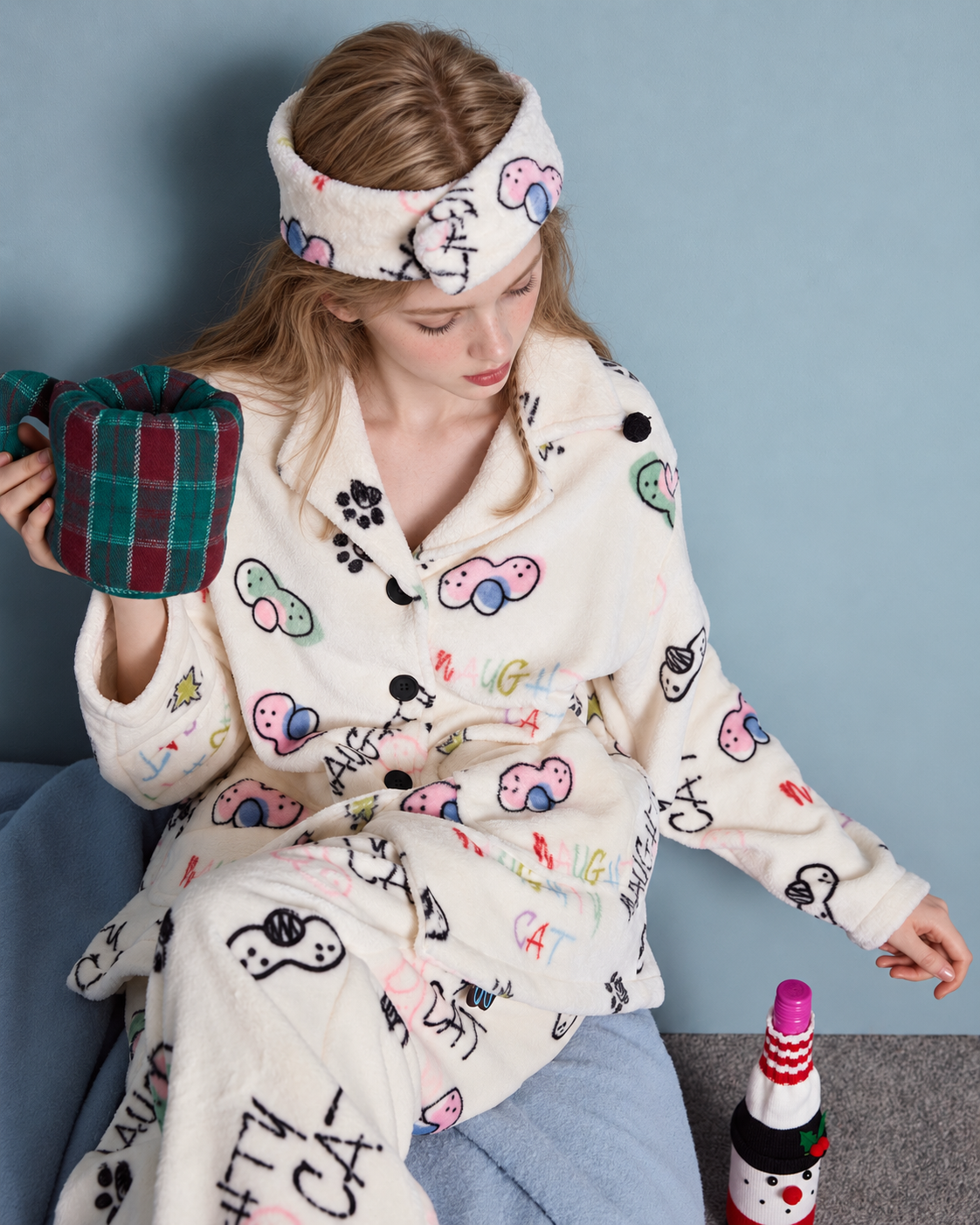 Doodlewhisk Cat Doodle Fleece Pajama Set – cream cat-print pajama set, seated holding a plaid cup - Roomden