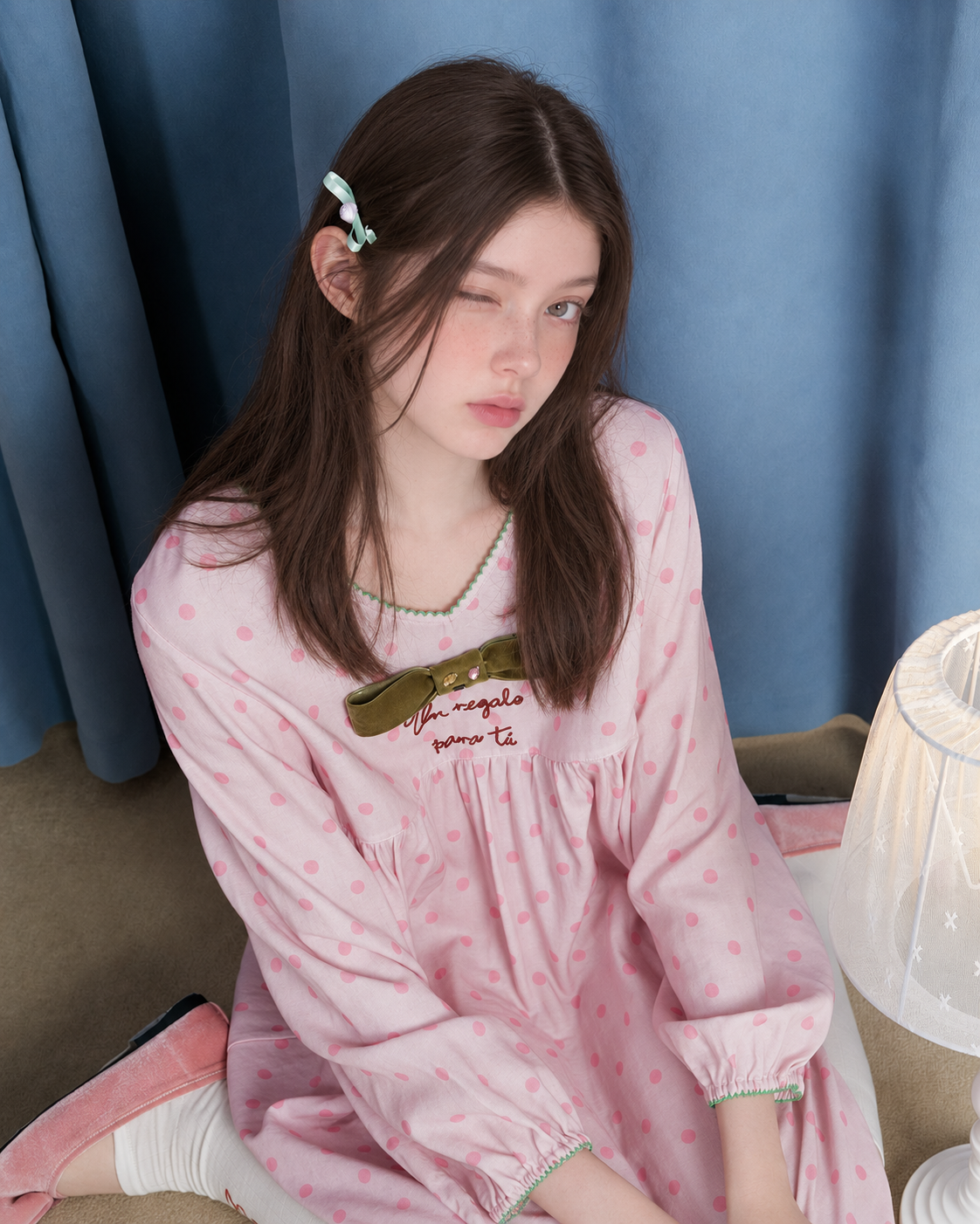 Polka Dot Bow Cotton Gauze Pajama Set – pink top, overhead view beside a blue curtain - Roomden
