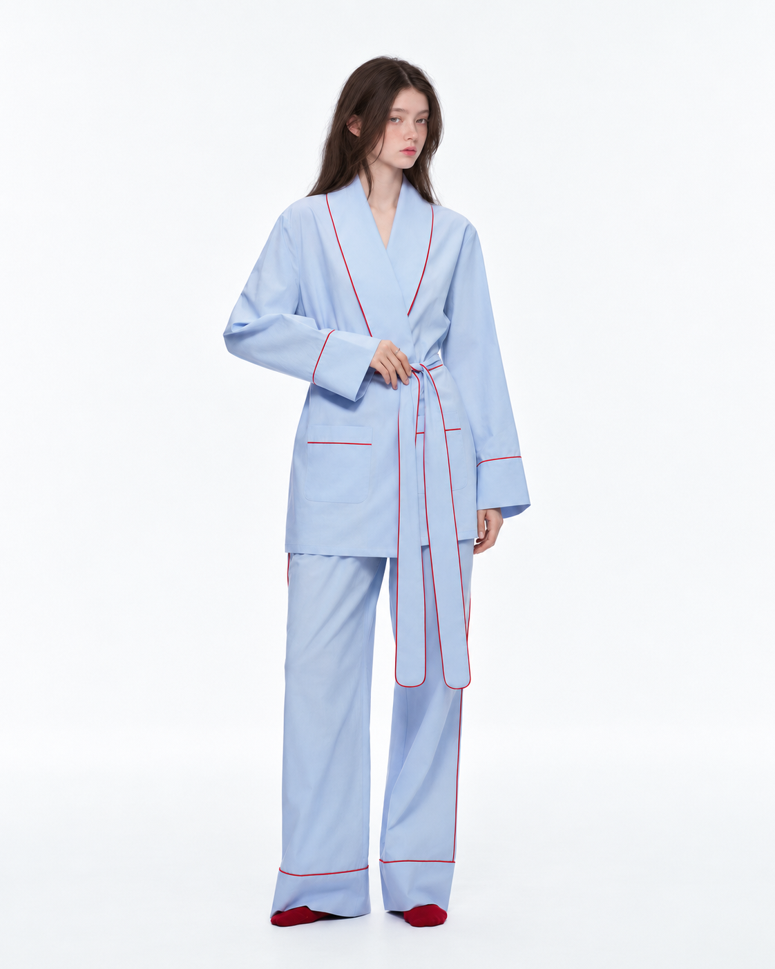 Linehaven wrap pajama set – Baby Blue, front view holding the waist tie in the studio - Roomden