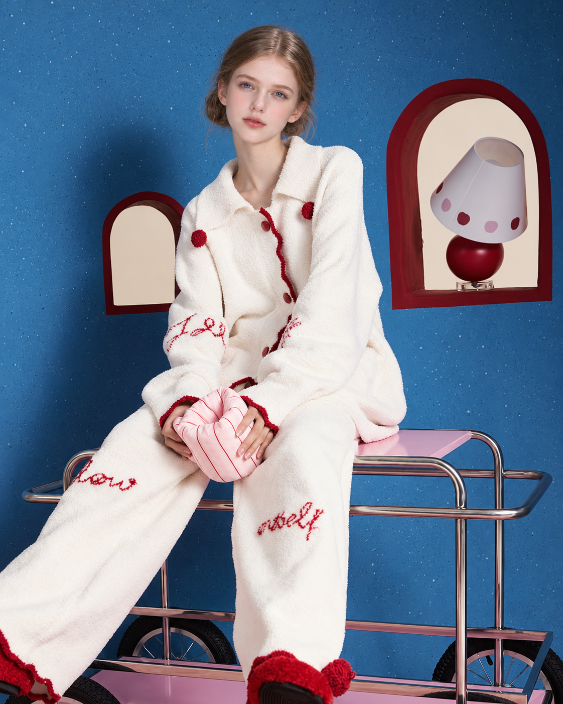 Pom-Pom Fleece Pajama Set – ivory bench-seated view showing long trousers and sleeve lettering - Roomden