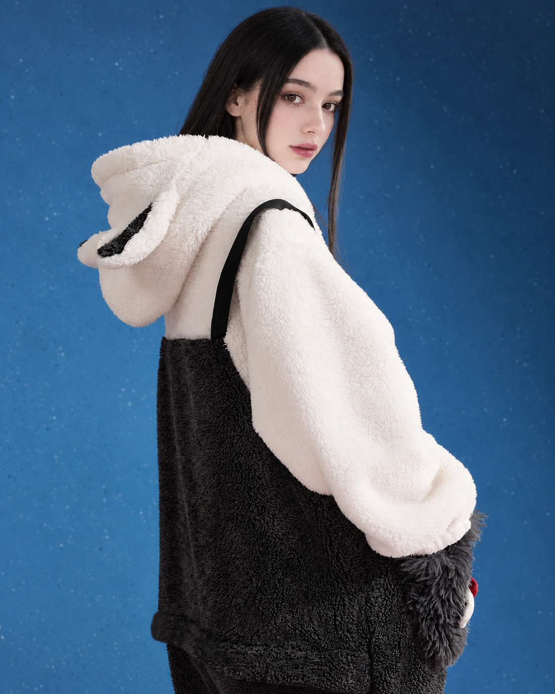 Rear three-quarter view showing hood and black-and-white fleece one-piece construction