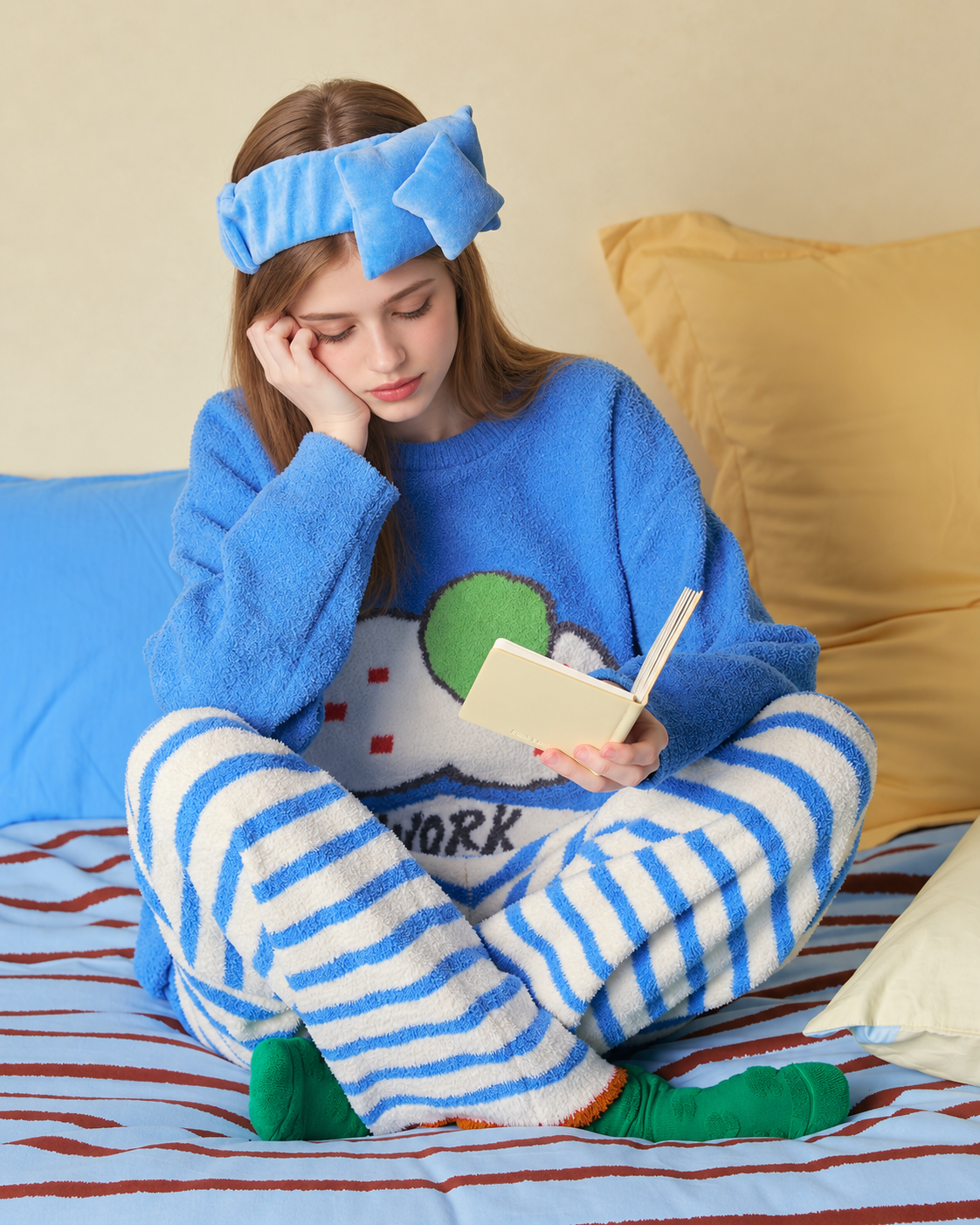 Blue cat graphic fleece pajama set with cream striped pants – Cross-legged reading on bed