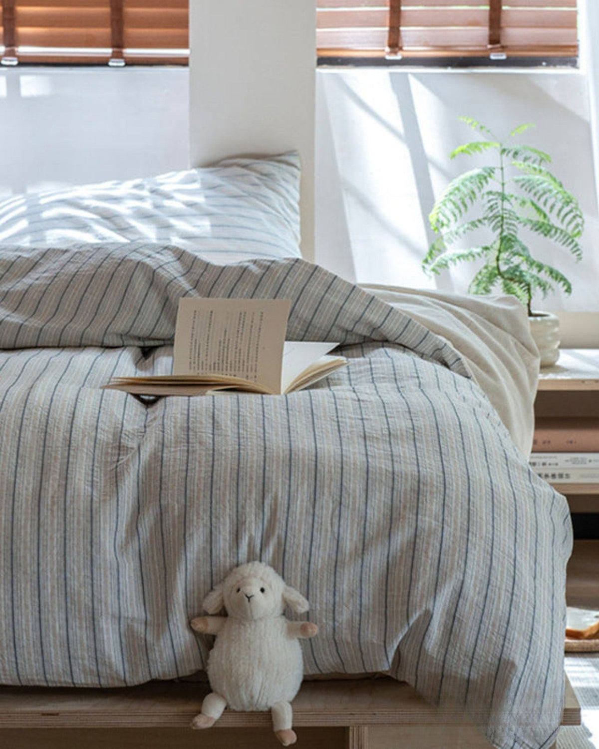 Winslet Pinstripe Cotton Bedding Set – front view of grey striped bedding beneath wooden blinds - Roomden