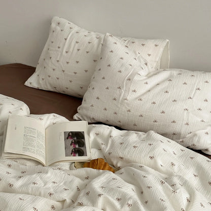 Lifestyle shot of RoomDen bedding with an open book, highlighting the cozy coquette aesthetic