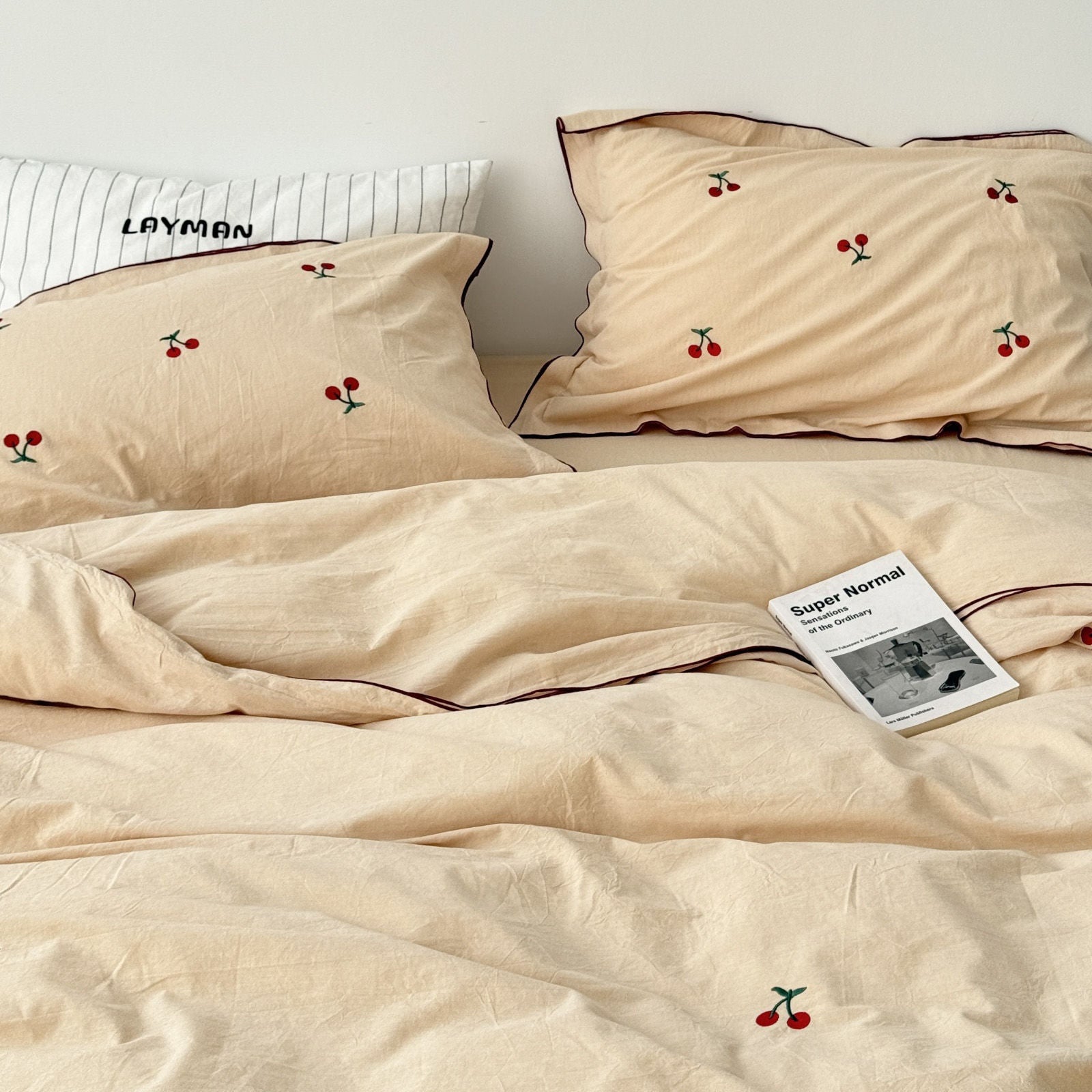 Beige cherry bedding set displayed on bed with pillows and duvet cover