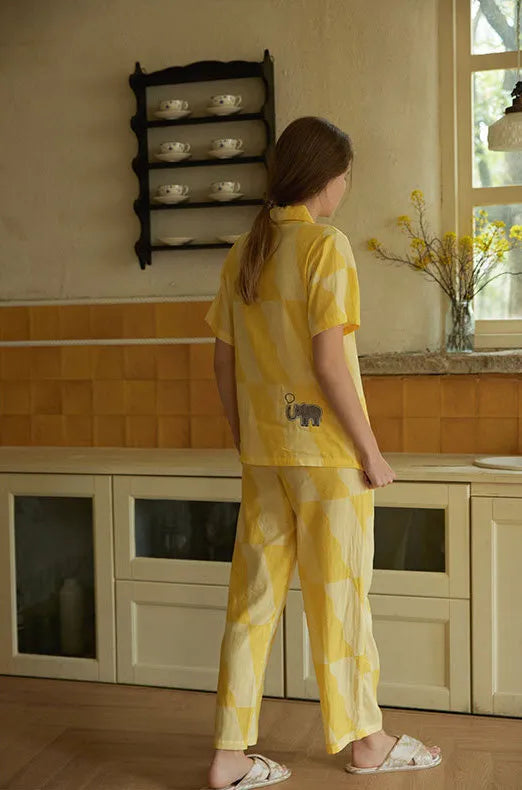 Woman wearing sunny yellow washed cotton pajama set with playful elephant patch, relaxed homewear look – RoomDen