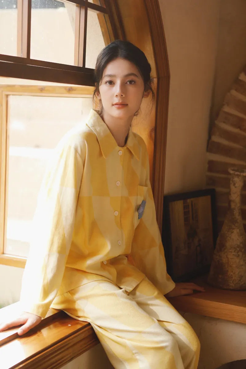 Sunny yellow checkered cotton pajama set worn by a woman sitting by an arched wooden window – RoomDen