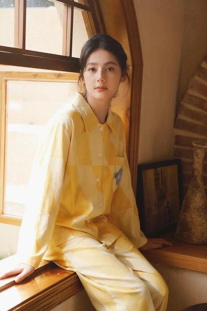 Sunny yellow checkered cotton pajama set worn by a woman sitting by an arched wooden window – RoomDen