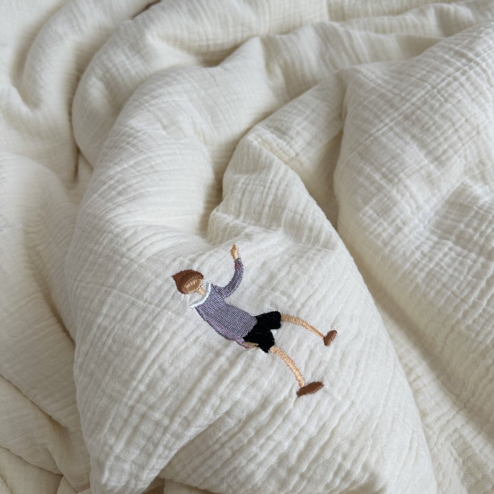 Detail shot of the White fabric with high-quality embroidery of a boy sitting.