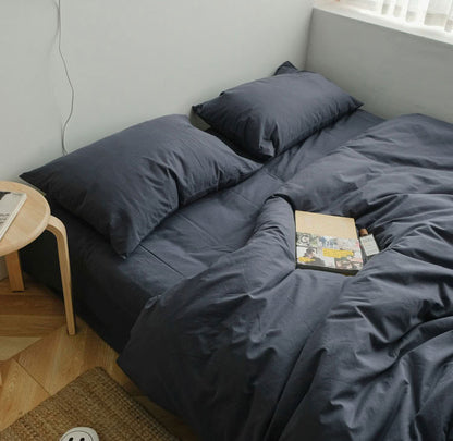Blue grey washed cotton bedding set with matching pillows, styled on a low bed near the windowBlue grey washed cotton bedding set with matching pillows, styled on a low bed near the window - RoomDen