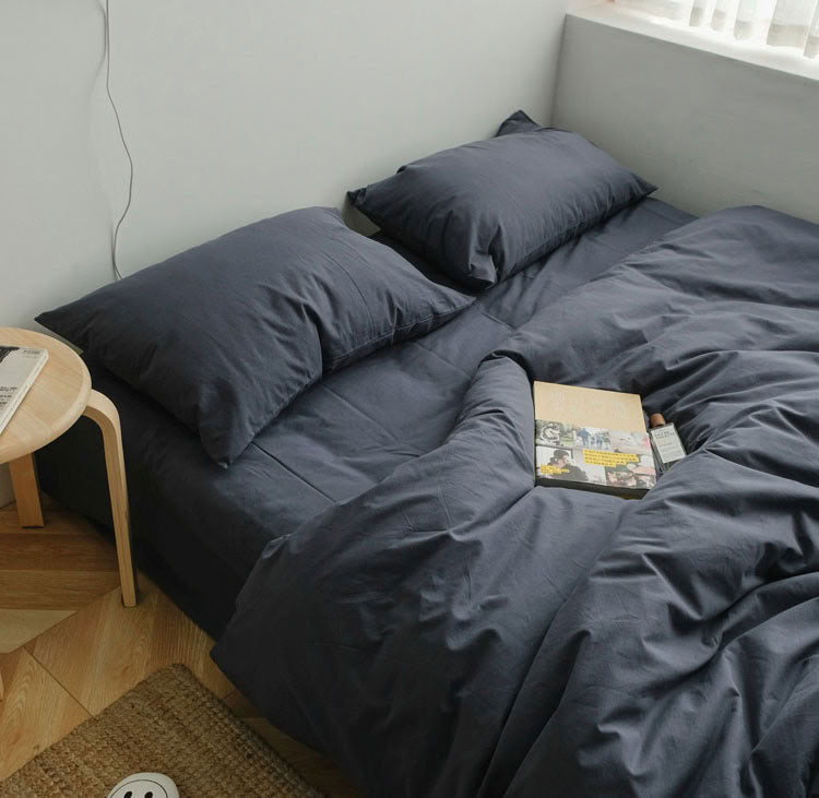 Blue grey washed cotton bedding set with matching pillows, styled on a low bed near the windowBlue grey washed cotton bedding set with matching pillows, styled on a low bed near the window - RoomDen