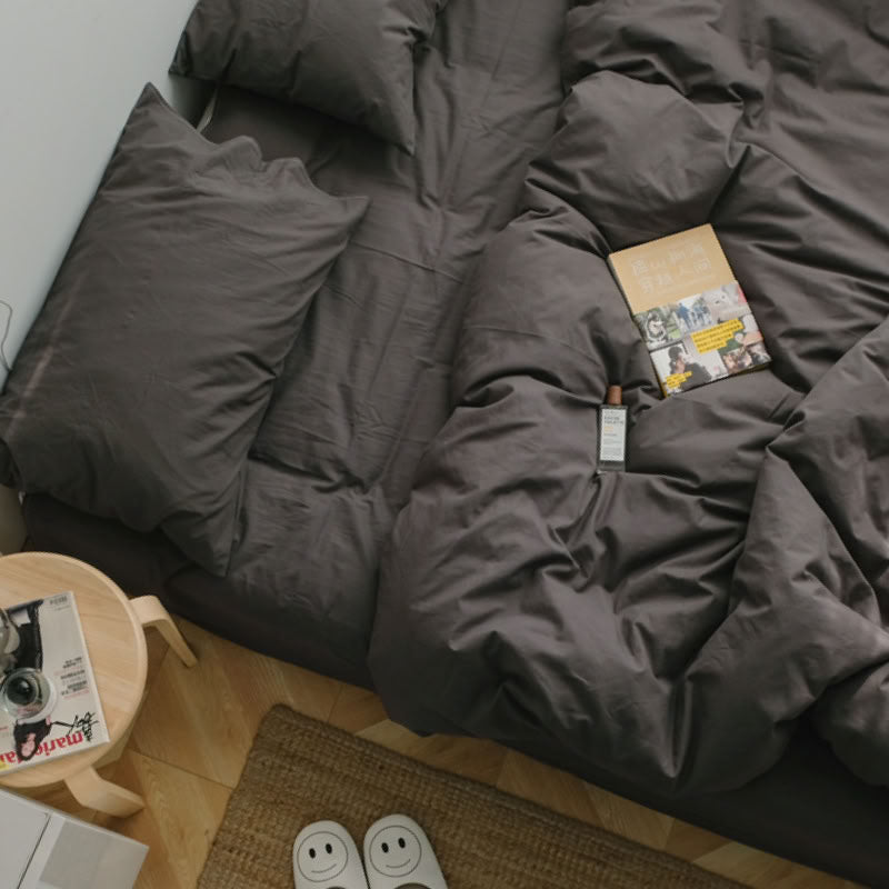 Soft brown grey washed cotton bedding set with a book and cozy morning setup on a wooden floor - RoomDen