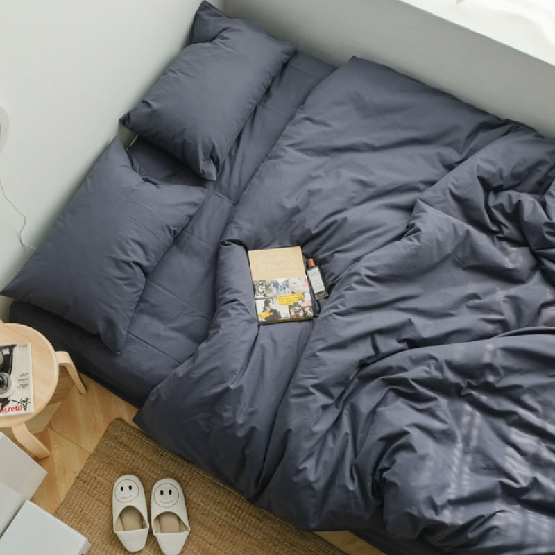 Soft blue grey washed cotton bedding set with a book and slippers, creating a calm morning vibeSoft blue grey washed cotton bedding set with a book and slippers, creating a calm morning vibe- RoomDen