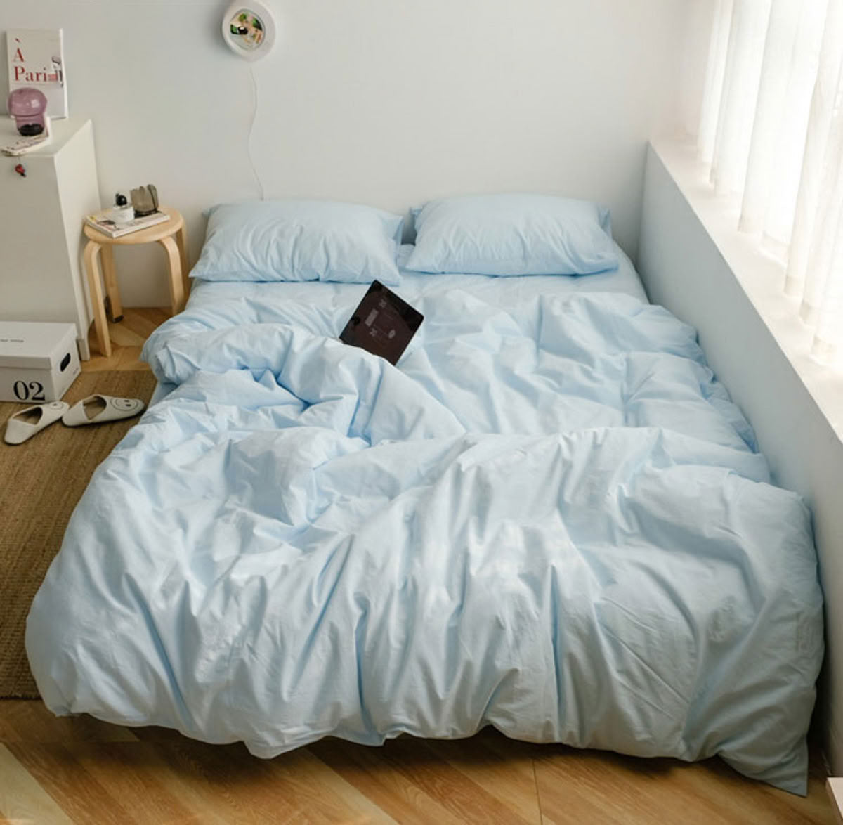 Cozy sky blue washed cotton bedding set with natural light and relaxed morning vibe - RoomDen