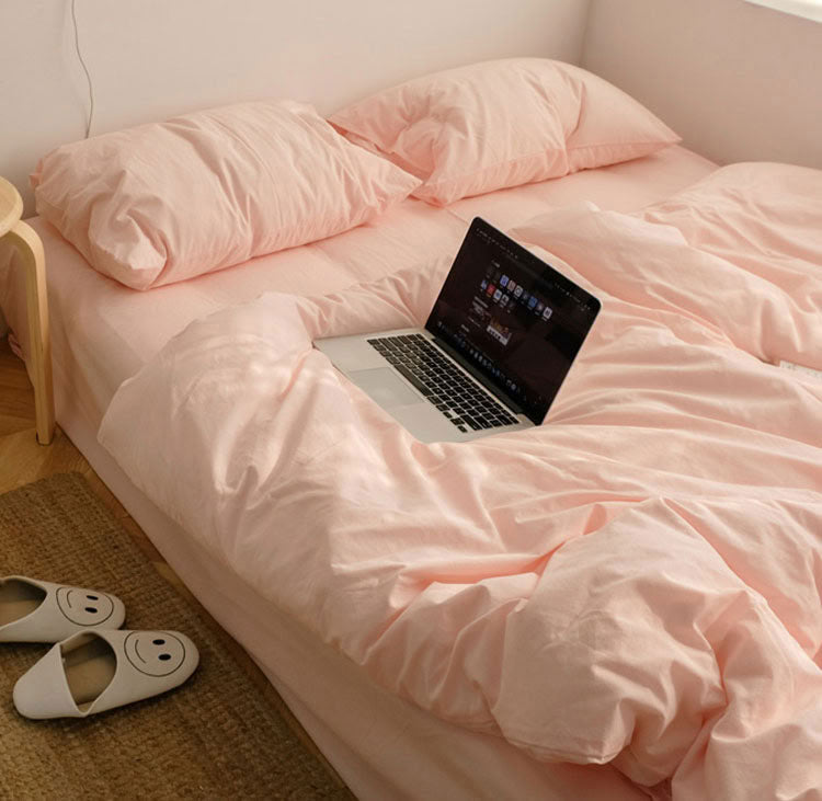 Soft rose pink washed cotton bedding set in a cozy minimalist bedroom with natural light - RoomDen