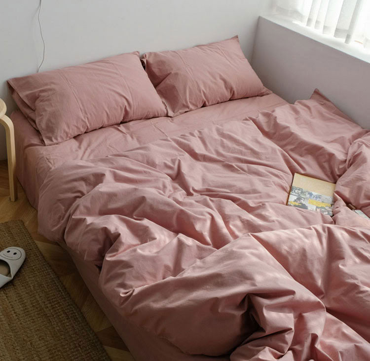 Blush pink washed cotton bedding set with pillows and a book on the bed - RoomDen