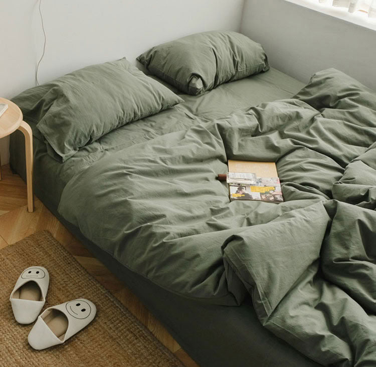Sage green washed cotton bedding set with pillows and a cozy minimalist setup - RoomDen