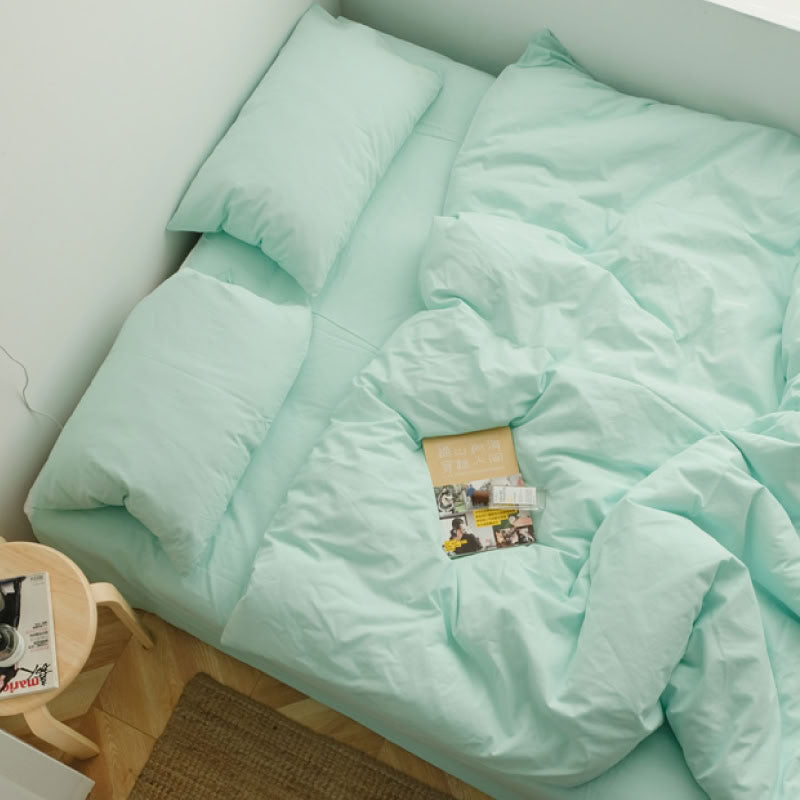 Soft Mint Green washed cotton bedding set with a book and warm natural light - RoomDen