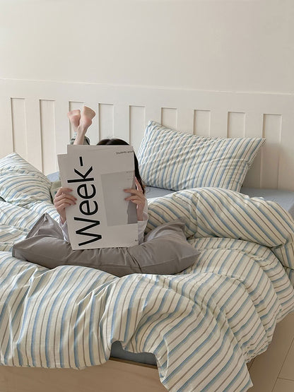 Relaxed morning scene with blue striped bedding and minimalist grey pillow – RoomDen