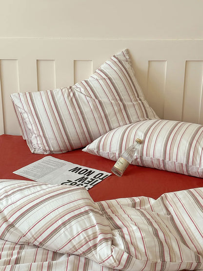 Minimalist bedroom featuring red striped cotton duvet cover and matching solid pillowcases – RoomDen