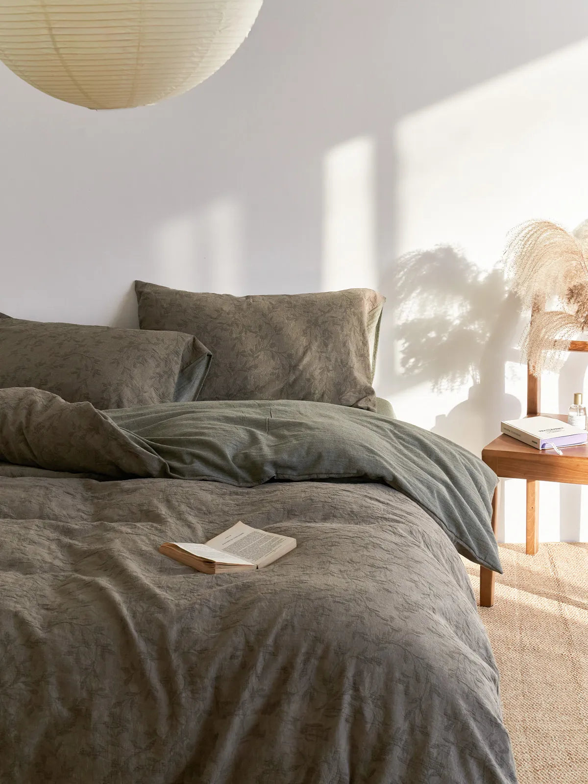 Side view of earthy grey floral bedding set with warm sunlight and shadows RoomDen.