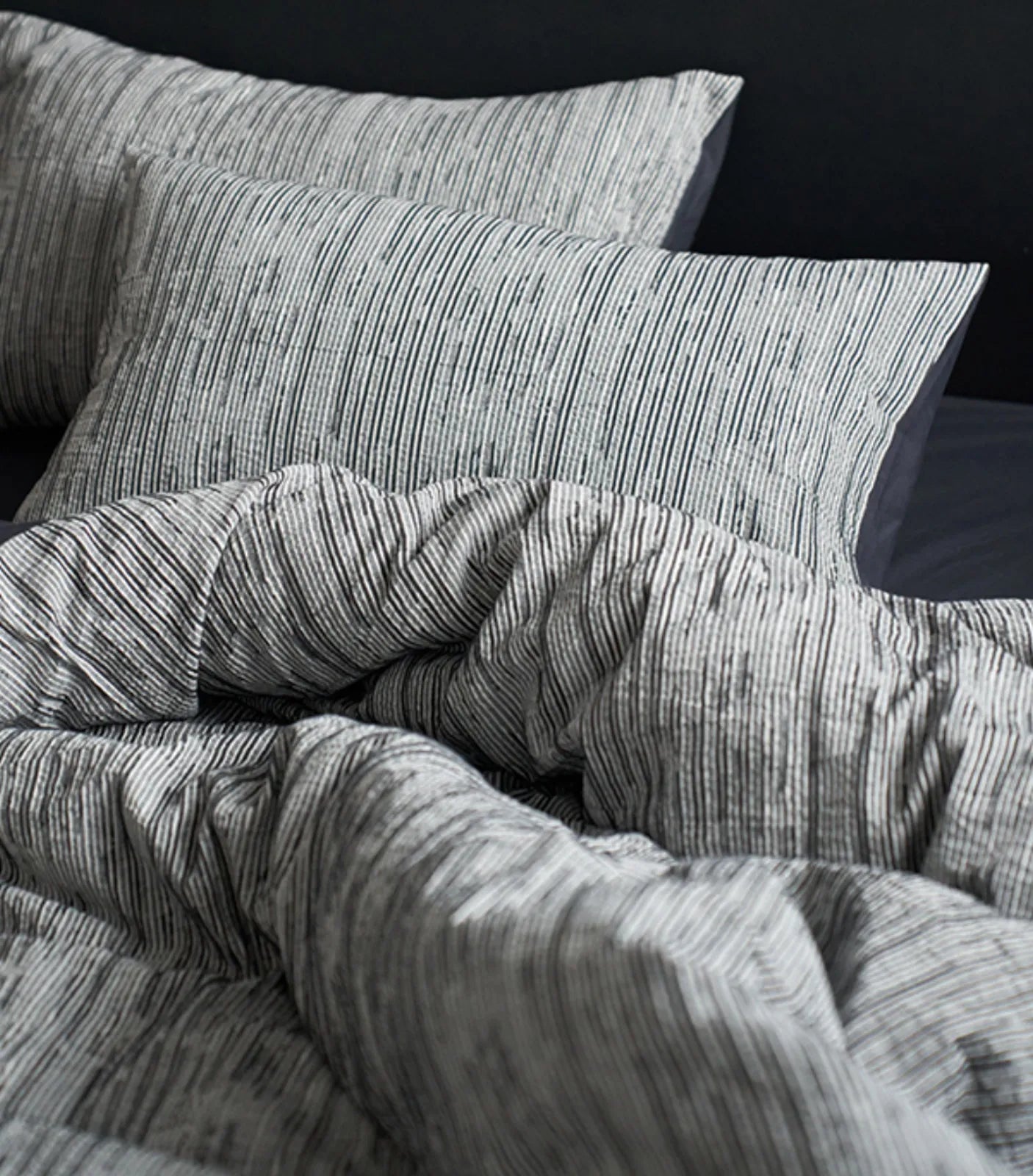 Pillows and duvet cover in charcoal grey pinstripe design close up RoomDen.