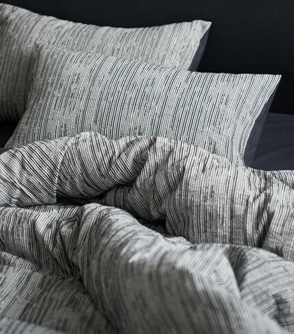 Pillows and duvet cover in charcoal grey pinstripe design close up RoomDen.