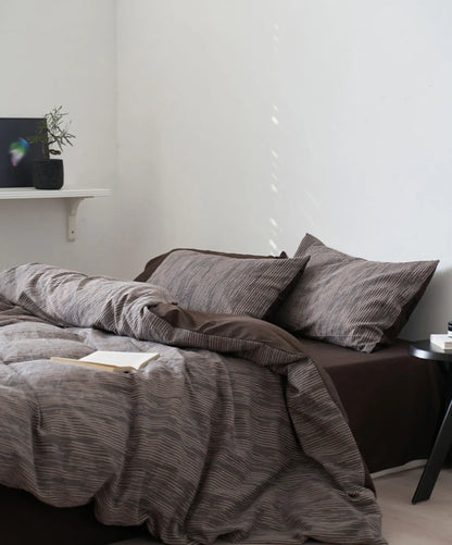 Full bed view of charcoal grey minimalist bedding set with side table RoomDen.