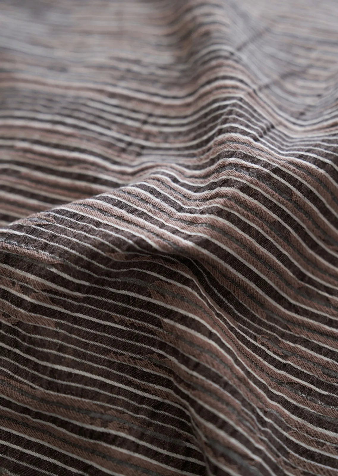 Extreme close up of washed cotton fabric weave and brown pinstripe detail RoomDen.