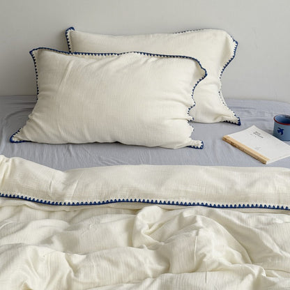 Close up of pillowcase corner with black triangle embroidery | RoomDen