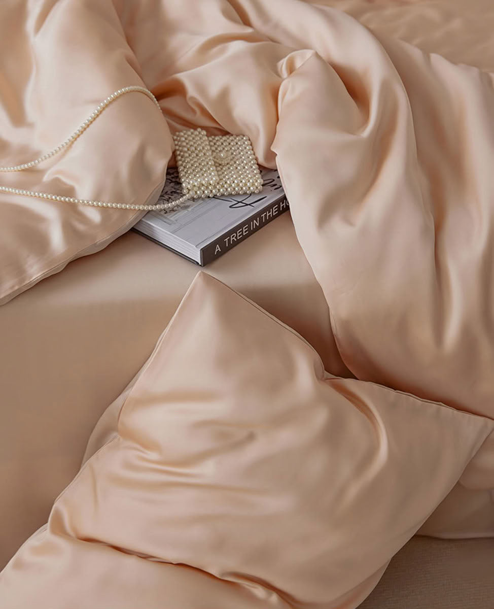Detailed shot of silky beige-pink bedding and pearl bag accent – RoomDen