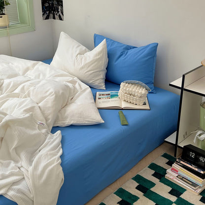 Crisp white duvet paired with bright blue sheet for fresh modern bedroom – RoomDen