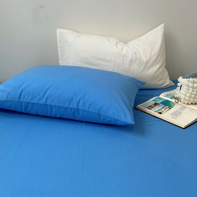 Soft cotton blue pillow and white pillowcase combination on solid bedding – RoomDen