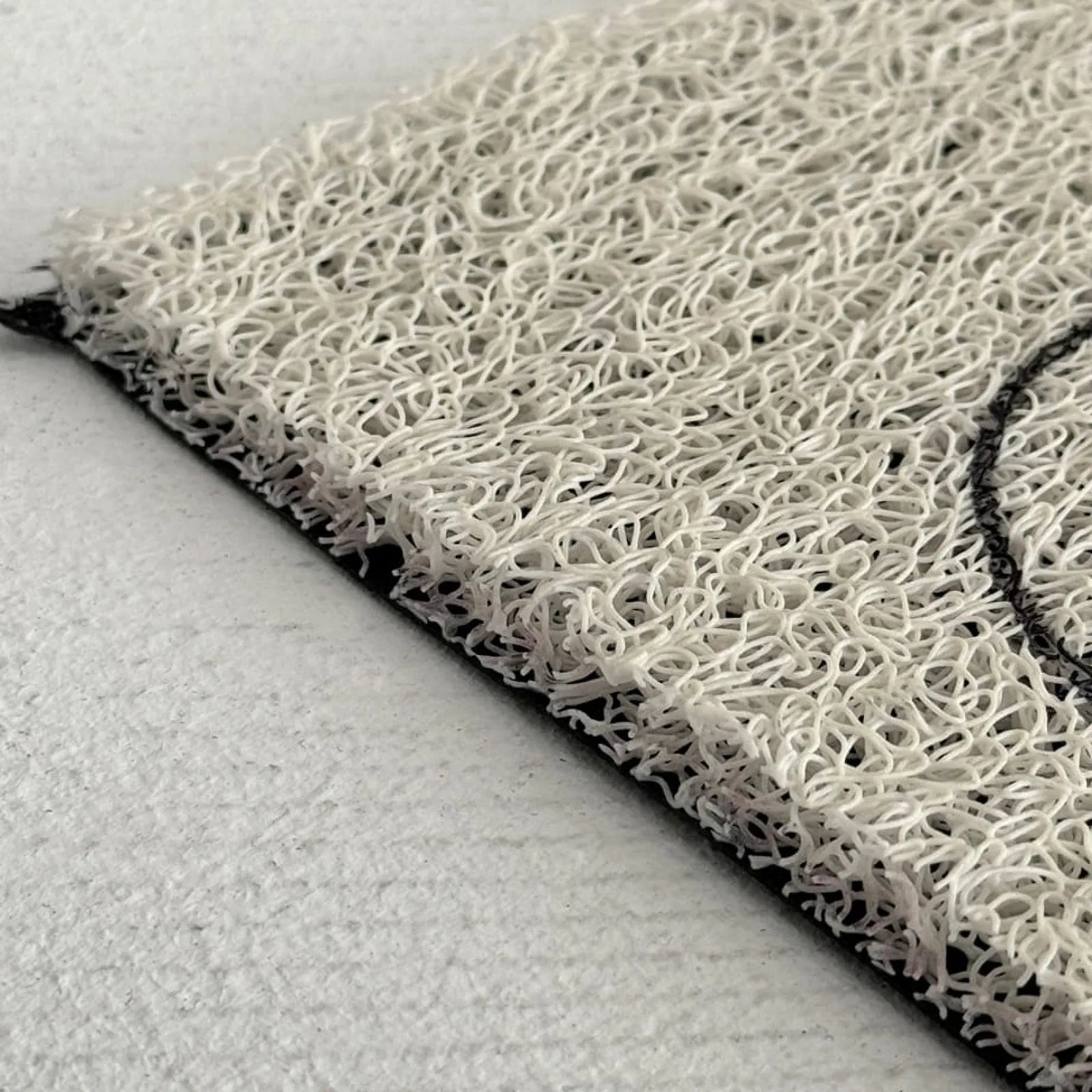 Close-up of the cream PVC coil texture showing the spaghetti loop structure and black edge.