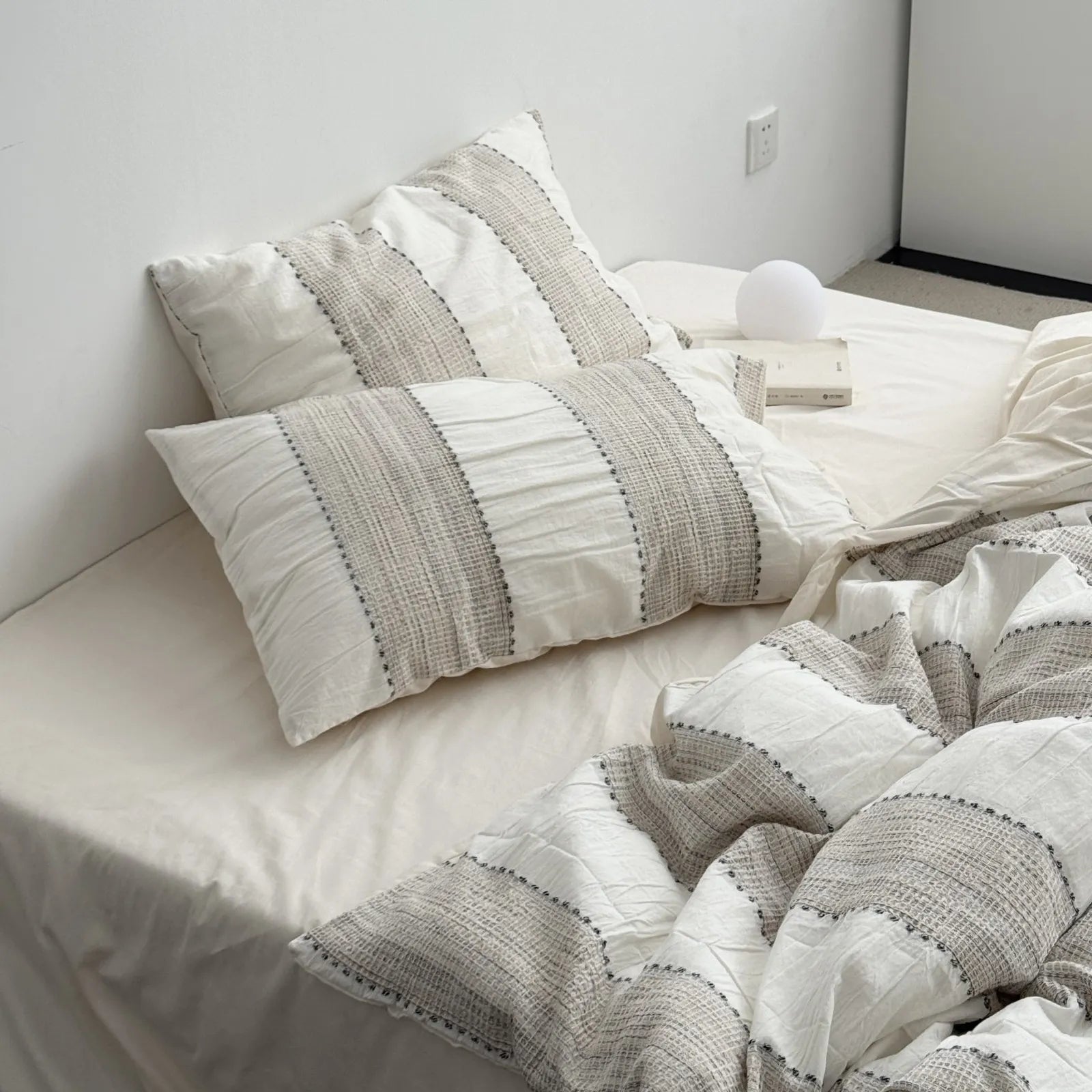 Beige washed cotton bedding set with textured waffle stripes on bed view 1 | RoomDen